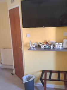 a flat screen tv on a wall with a shelf at No 27 in Inverness