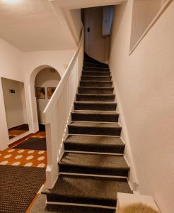 eine Treppe in einem Haus mit schwarzen Treppen in der Unterkunft Guesthouse in Weeze in Weeze