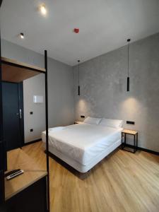 sypialnia z dużym białym łóżkiem i dwoma stołami w obiekcie Sweet Sevilla Hostel w Sewilli