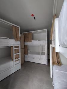 2 białe łóżka piętrowe w pokoju w obiekcie Sweet Sevilla Hostel w Sewilli