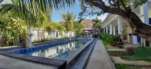a swimming pool in front of a house at Bali Diversity Dive Resort in Amed