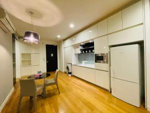 eine Küche mit einem Tisch und einem weißen Kühlschrank in der Unterkunft The Platinum Suite Kuala Lumpur By Home Style in Kuala Lumpur