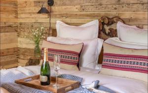 a bottle of wine sitting on a bed with pillows at Unique Secluded Romantic Treehouse in Cornwall, sleeps 2 in Looe