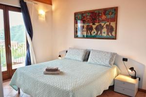a bedroom with a bed and a painting on the wall at Casa Aaron in Tremosine Sul Garda