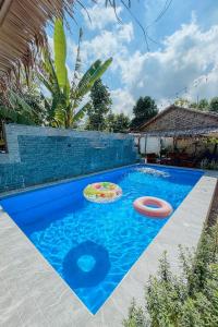 a blue swimming pool with two frisbees in it at Woodenhousevilla suratthani-วิลล่าบ้านไม้สุราษฎร์ in Ban Kadae Chae