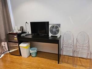 a desk with a computer and a fan and two chairs at Private guest suite in Perth