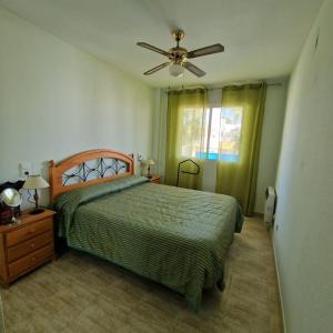 Schlafzimmer mit einem Bett und einem Deckenventilator in der Unterkunft Marimar 11/10 in Oliva