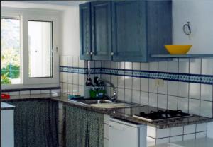 a kitchen with blue cabinets and a sink at L'Isolana Case Vacanza Alloro 3 in Ponza