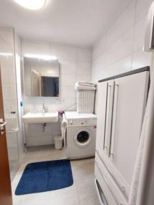 ein Badezimmer mit einer Waschmaschine und einem Waschbecken in der Unterkunft 1Room in a beautiful shared apartment 12min walk from Center in Friedrichshafen