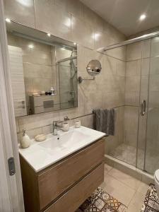 uma casa de banho com um lavatório e um chuveiro em appartement luxueux a hydra em Alger