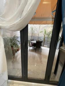 uma vista para um quarto com uma porta de vidro e uma mesa em appartement luxueux a hydra em Alger