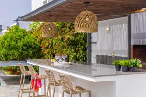 Una cocina al aire libre con barra y sillas. en Green Heaven Villa 3, en Protaras 94 fotos más