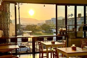 a restaurant with tables and chairs and a large window at Gyeongju BonghwangMansion in Gyeongju