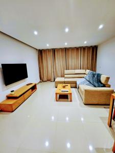 a living room with a couch and a flat screen tv at Flamingo Plateau 1A apt on Rua Pedonal Praia Cape Verde in Praia