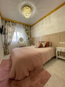 Casa Amarela Guesthouse, Algorfa في الغرفة: غرفة نوم بسرير كبير وثريا