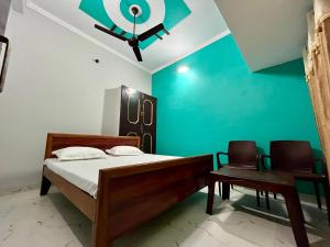 1 dormitorio con cama y pared verde en Sainik Homestay, Ayodhya en Ayodhya