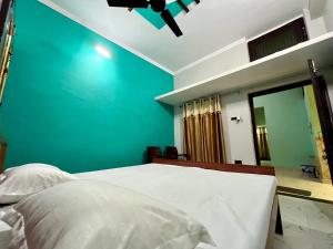 1 dormitorio con 1 cama con pared azul en Sainik Homestay, Ayodhya en Ayodhya