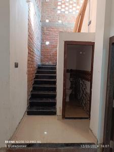 Una escalera en una habitación con una pared de ladrillo en Kailash home, en Deoghar