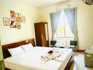 洞海的住宿－View Nhat Le Beach Hotel，卧室配有带鲜花的白色床