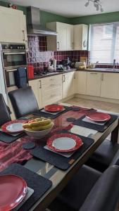 a kitchen with a table with plates and bananas on it at House with free parking and large garden in Wyke Regis