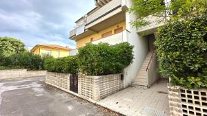 un edificio con cancello e cespugli accanto a una strada di M095 - Marcelli, trilocale ristrutturato a 100 m dal mare a Marcelli