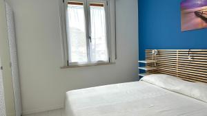 una camera da letto con un letto e una finestra di M095 - Marcelli, trilocale ristrutturato a 100 m dal mare a Marcelli