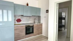 una cucina con mobili in legno, un lavello e una stufa di M095 - Marcelli, trilocale ristrutturato a 100 m dal mare a Marcelli