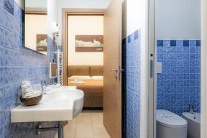 a bathroom with blue tiles and a toilet and a sink at Affittacamere del Golfo e delle 5 Terre in La Spezia