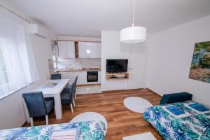 a kitchen and living room with a table and chairs at Apartman Neca Trebinje in Trebinje