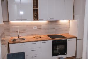 a kitchen with white cabinets and a sink at Apartman Neca Trebinje in Trebinje