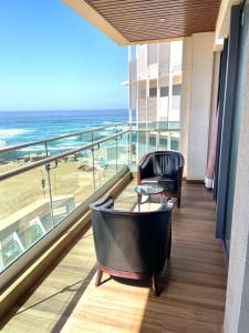 a balcony with a table and a chair and the ocean at Aquanique Luxury Living in Dakar