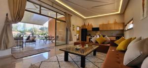 ein Wohnzimmer mit einem Sofa und einem Tisch in der Unterkunft Le jardin de Jeanne in Marrakesch