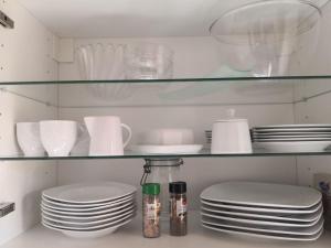 a kitchen shelf with plates and dishes on it at Kleine einzigartige Ferienwohnung auf dem Bauernhof, direkt in der Natur mit Blick auf Schloss Braunfels in Braunfels +45 photos