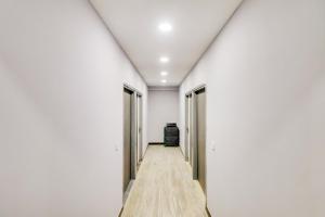 - un couloir dans une chambre dotée de murs blancs et de parquet dans l'établissement Super OYO Flagship HOTEL DREAM STAY, à New Delhi