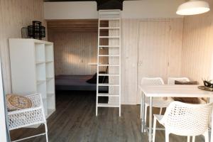 a room with a bunk bed and a table and chairs at Brouwersdam Stay in Ouddorp