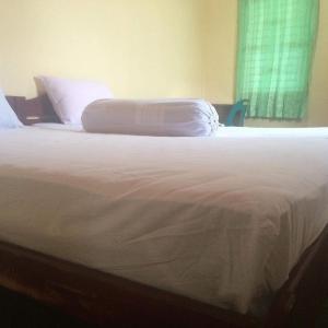 Lagudri的住宿－Endi Surf Camp，卧室内的一张带两个枕头的床