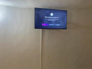 TV de pantalla plana colgada en la pared en Le teranga royale lodge, en Nianing