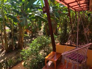 a hammock in a garden with trees and plants at One World Bungalows in Ko Lanta