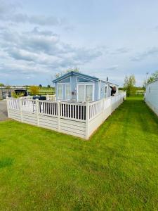 una pequeña casa azul con una valla blanca en Thorne Lodge - Seaview - 3 Bedroom en Whitstable