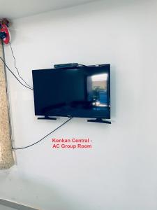 Elle comprend une télévision à écran plat suspendue sur un mur blanc. dans l'établissement Konkan Central Kankavali - Service Apartment, à Kankauli