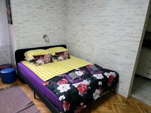 a bedroom with a bed with flowers on it at Apartment "GARDEN" on Gundulićeva 8 in Novi Sad