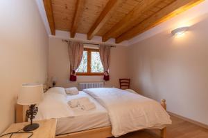 a bedroom with a large white bed and a window at Residence Rosental in Alleghe