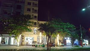 a city street at night with cars parked in front of a building at Xuân Lan Hotel in Thương Xà (2)