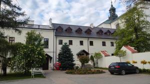 a car parked in front of a large white building at Centrum Dialogu Kultur in Węgrów