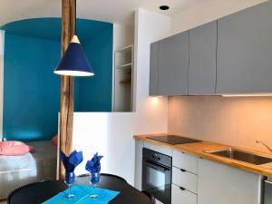 eine Küche mit einem Tisch und einer blauen Wand in der Unterkunft Auterive-Évasions-Éclipse-parking gratuit, hypercentre, gare in Auterive