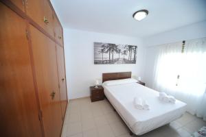 ベニカシムにあるATLANTA primera linea Orangecostaのベッドルーム1室(ベッド1台、タオル2枚付)