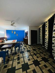 Roomshala 167 Hotel Red Near AIIMS في نيودلهي: غرفة معيشة مع طاولة والجدار الأزرق