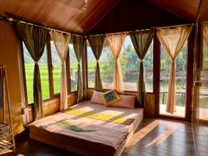 ein Schlafzimmer mit einem Bett in einem Zimmer mit Fenstern in der Unterkunft An's House in Ha Giang