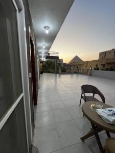 - un balcon avec une table et une chaise dans un bâtiment dans l'établissement Pyramids Khufu House, au Caire