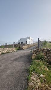 an empty road next to a stone wall and a building at الاردن جرش سوف المناره بالقرب من لواء قصبة جرش شاليه الكوت الاردني in Khirbat Ra”s al Madīnah